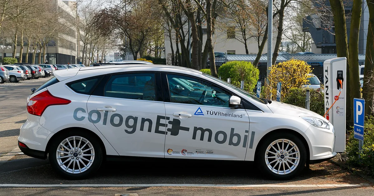 Elbil koblet til en ladestolpe på en parkeringsplass